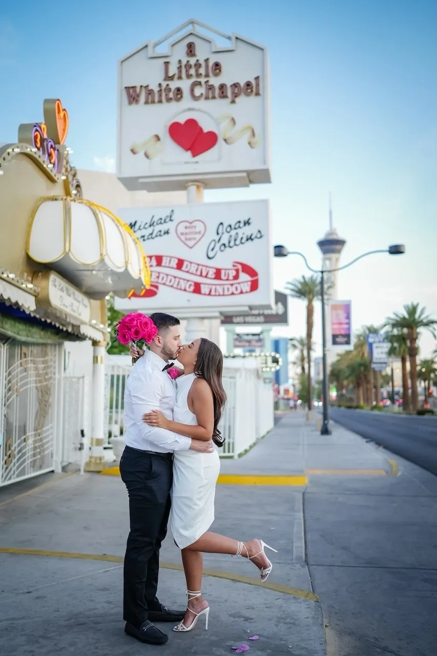 A man and woman kissing on the street.