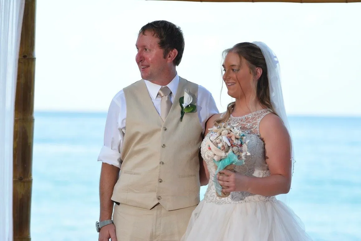 A man and woman standing next to each other on the beach.