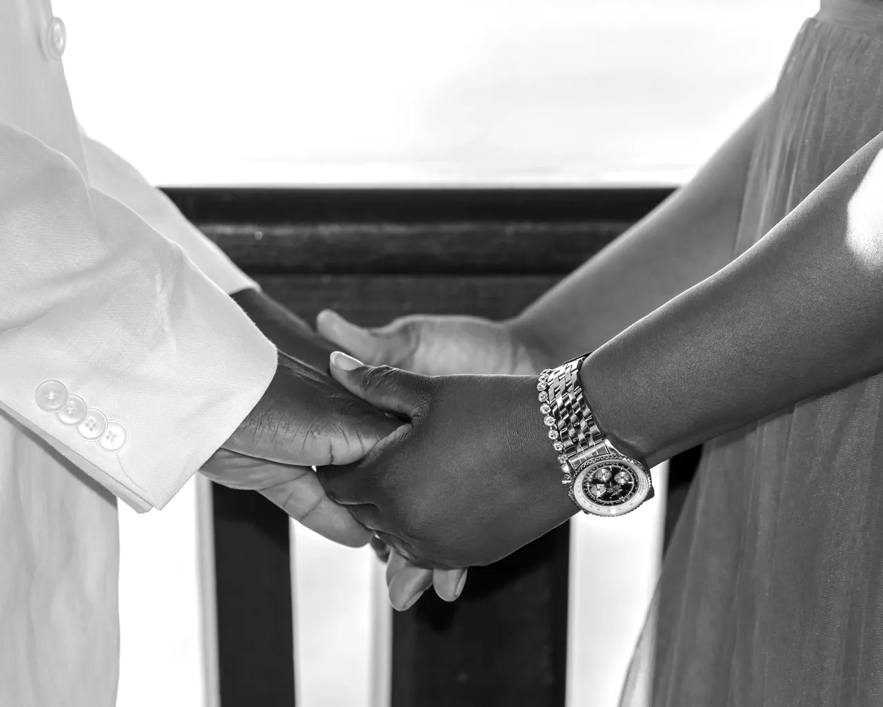 A man and woman holding hands in front of each other.