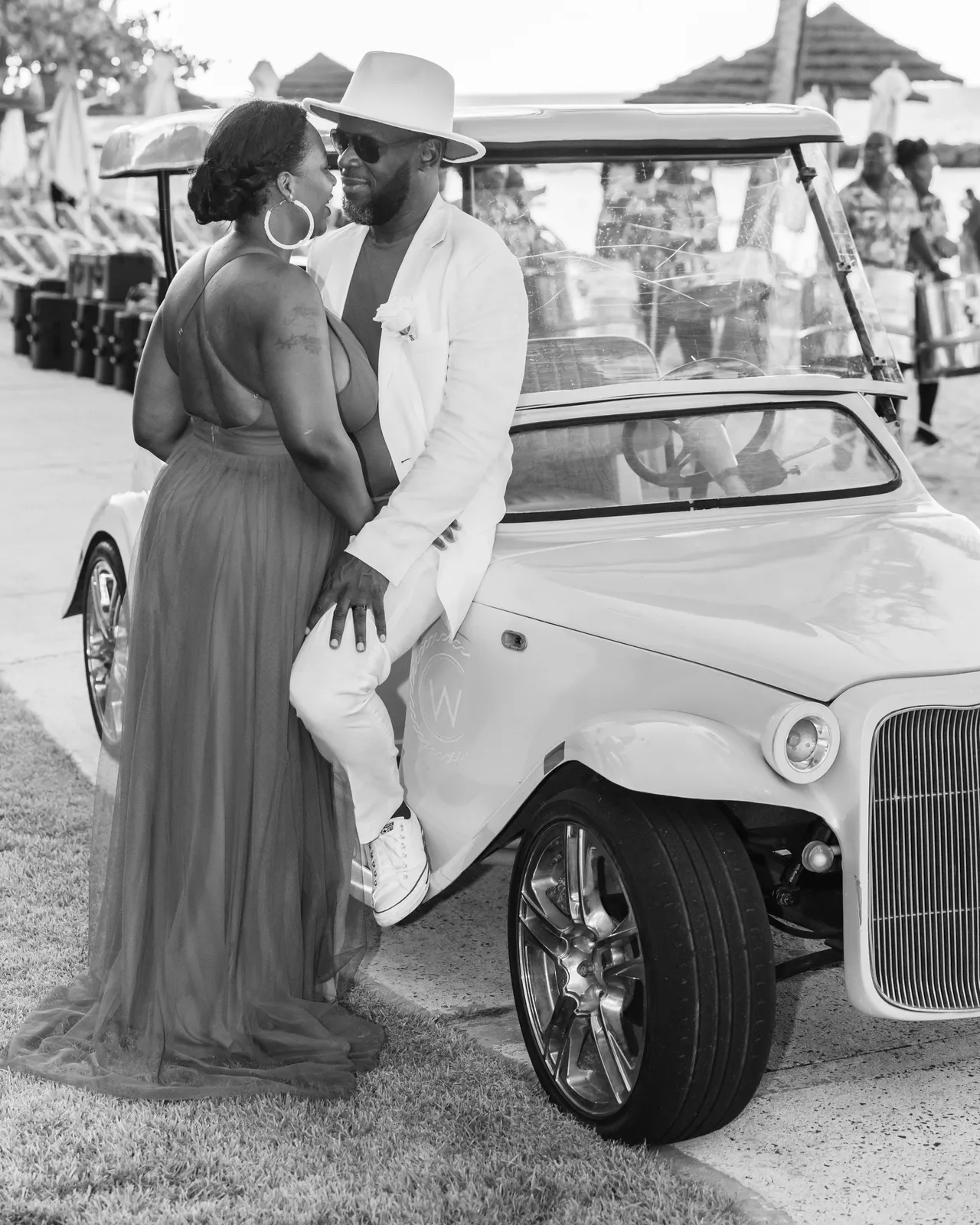 A man and woman standing next to a car.