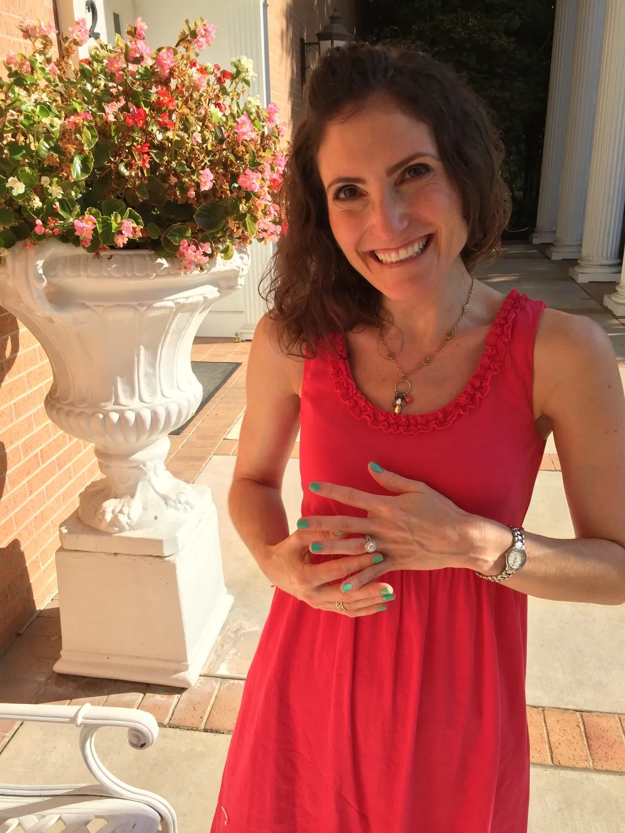 A woman in red dress holding her hands together.