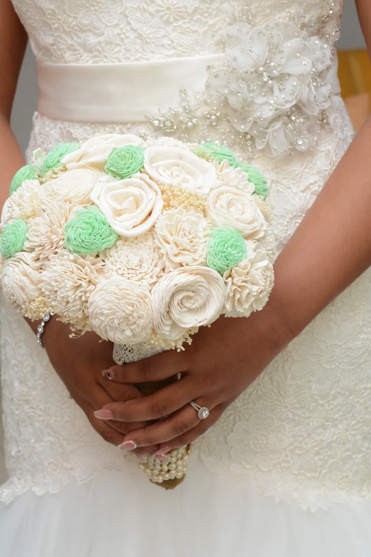 A bride holding her bouquet of flowers in front of her face.