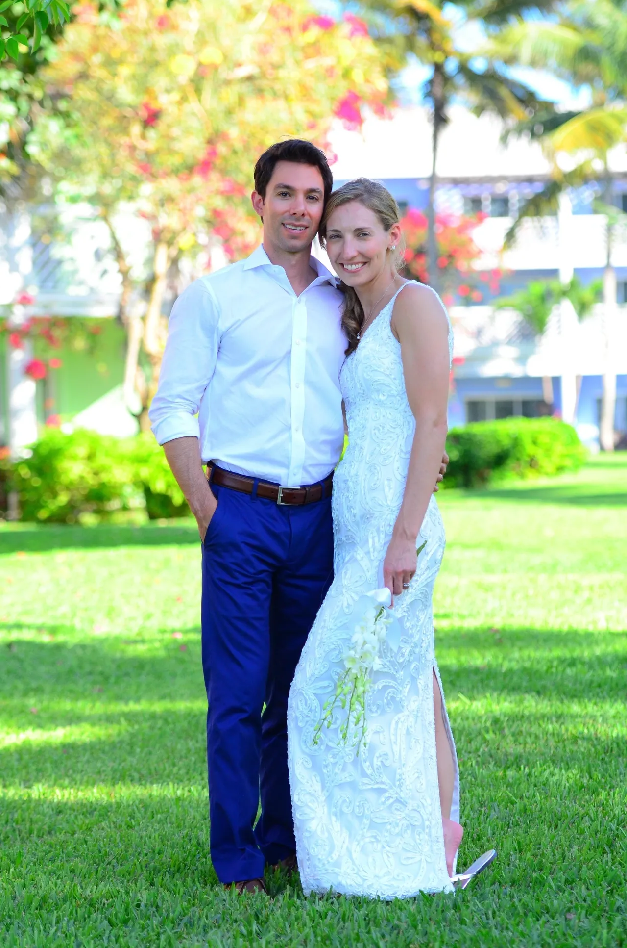 A man and woman posing for a picture in the grass.