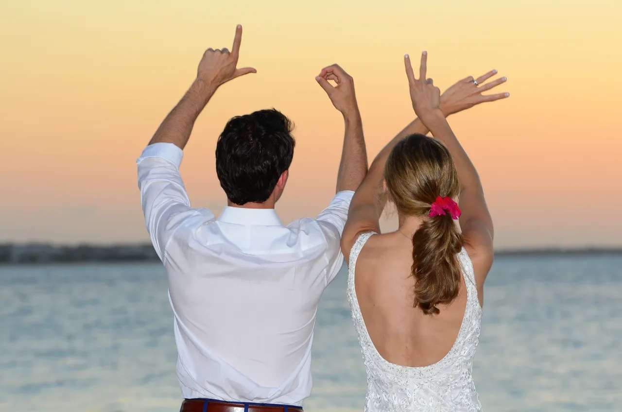 A man and woman standing next to each other on the beach.