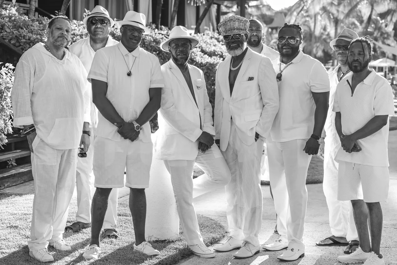 A group of men in white suits and hats.