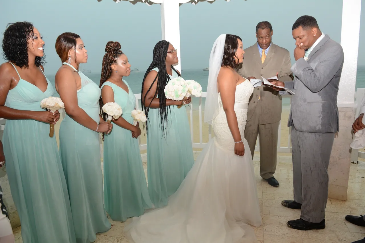 A bride and groom are standing with their wedding party.