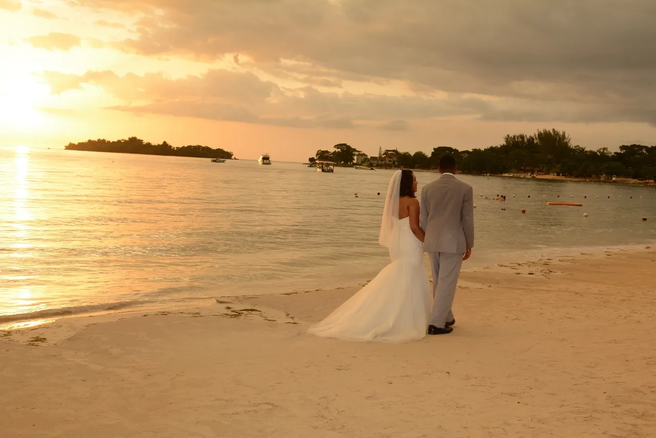 A couple walking on the beach at sunset