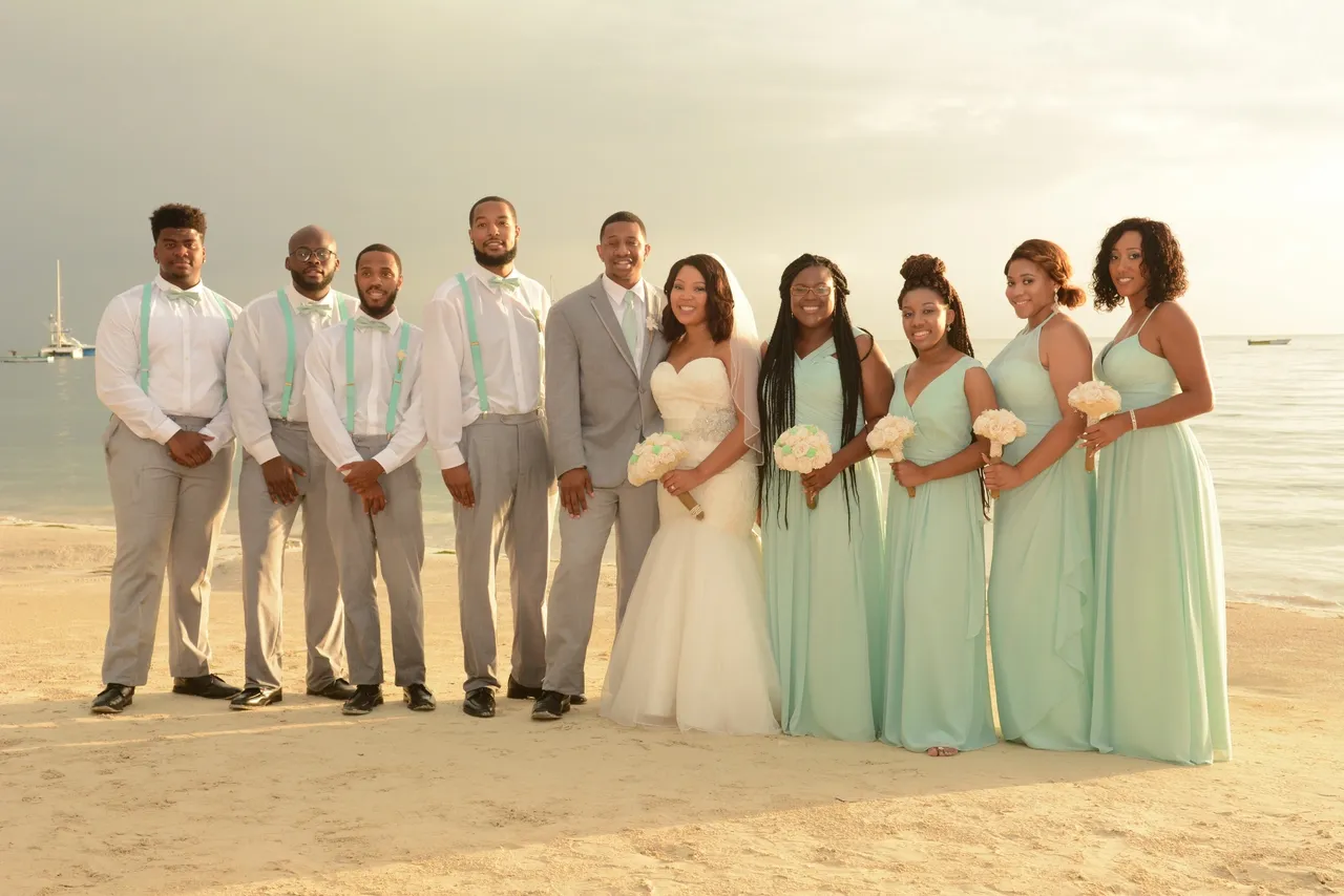 A group of people standing on top of a sandy beach.