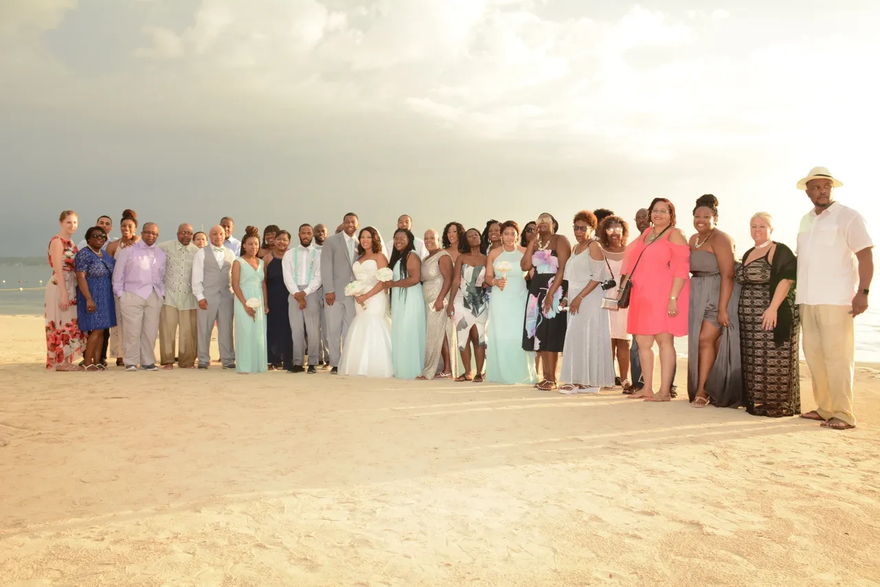 A group of people standing on top of a sandy beach.