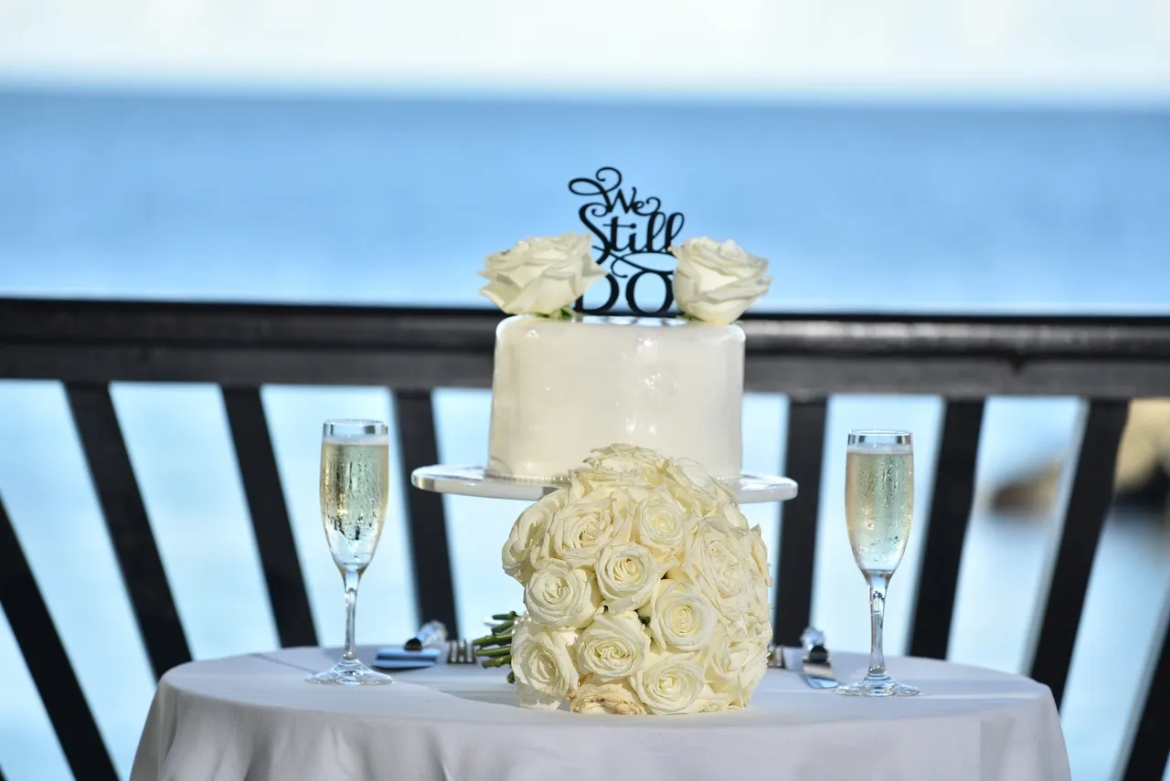 A table with two glasses and a cake on it