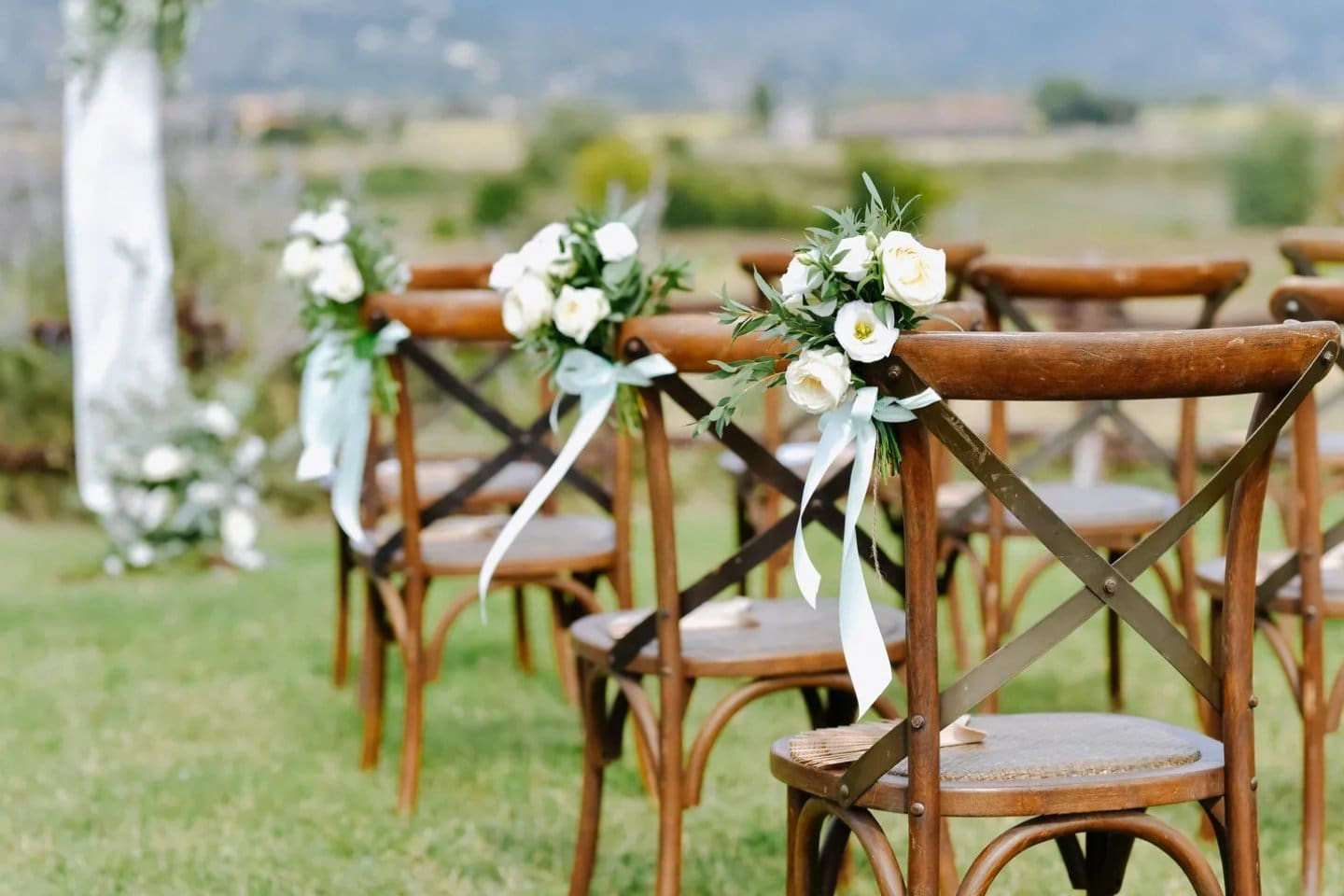 A row of wooden chairs with flowers on them.
