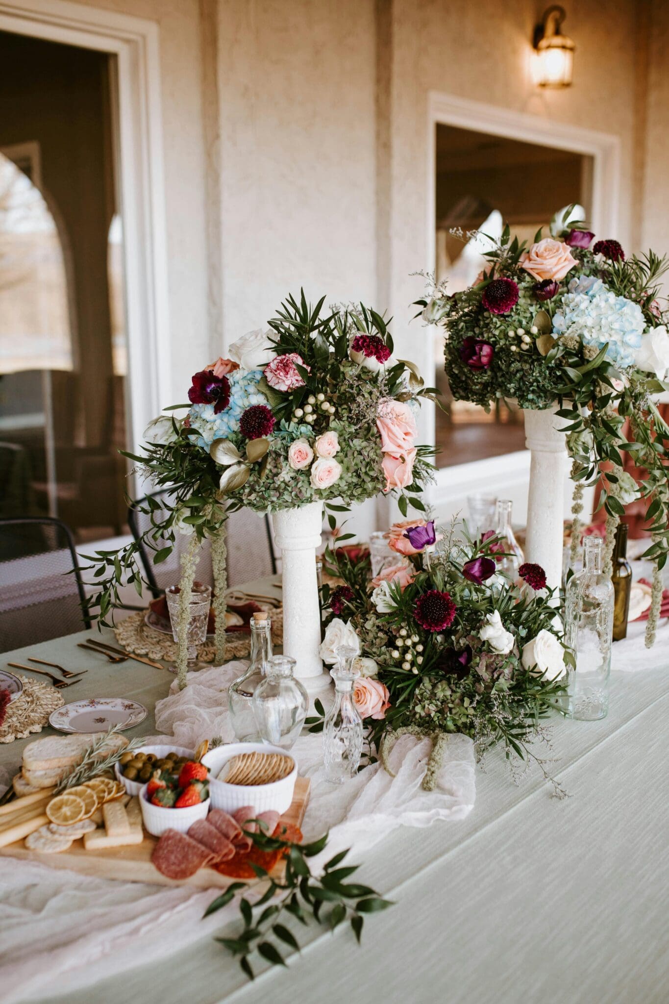 A table with flowers and plates of food on it.