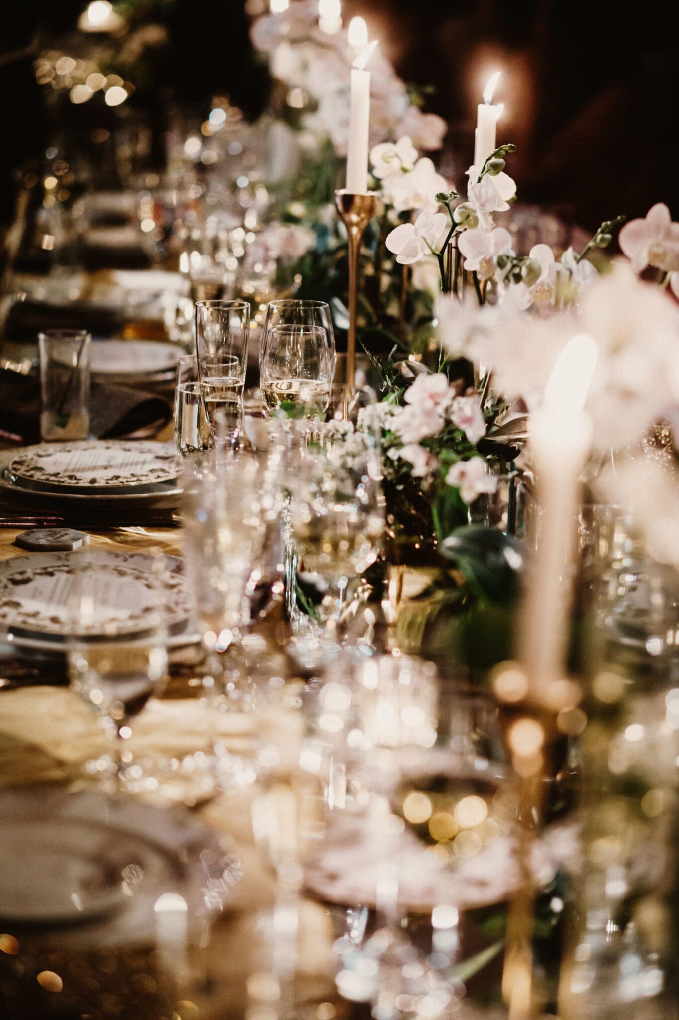 A table set with plates, glasses and candles.