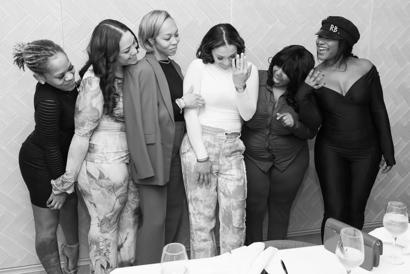 Six women laughing together at a party.