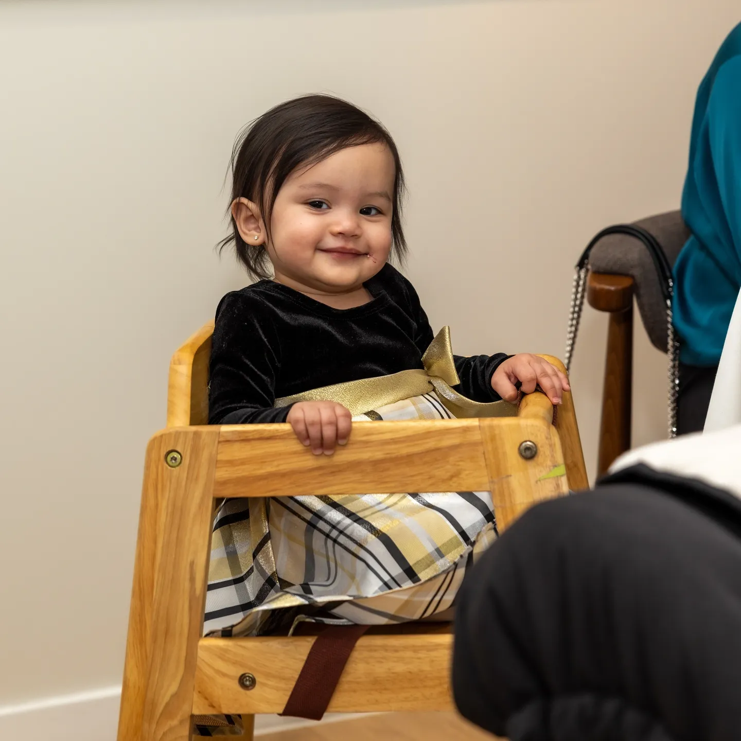 Smiling toddler girl in high chair.