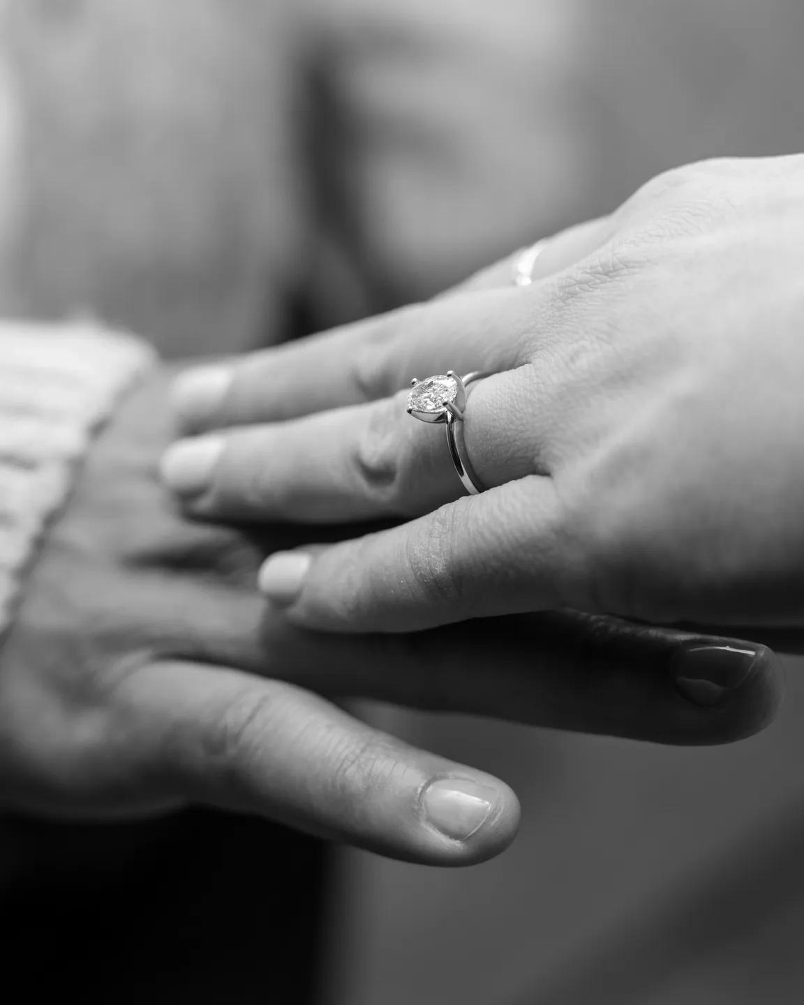 Couple's hands with engagement ring.