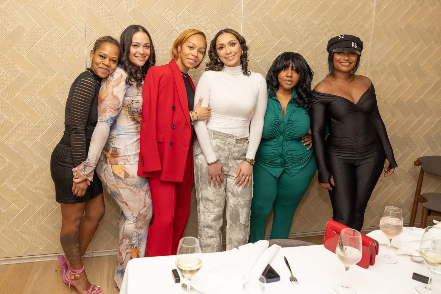 Six women pose together at a restaurant.