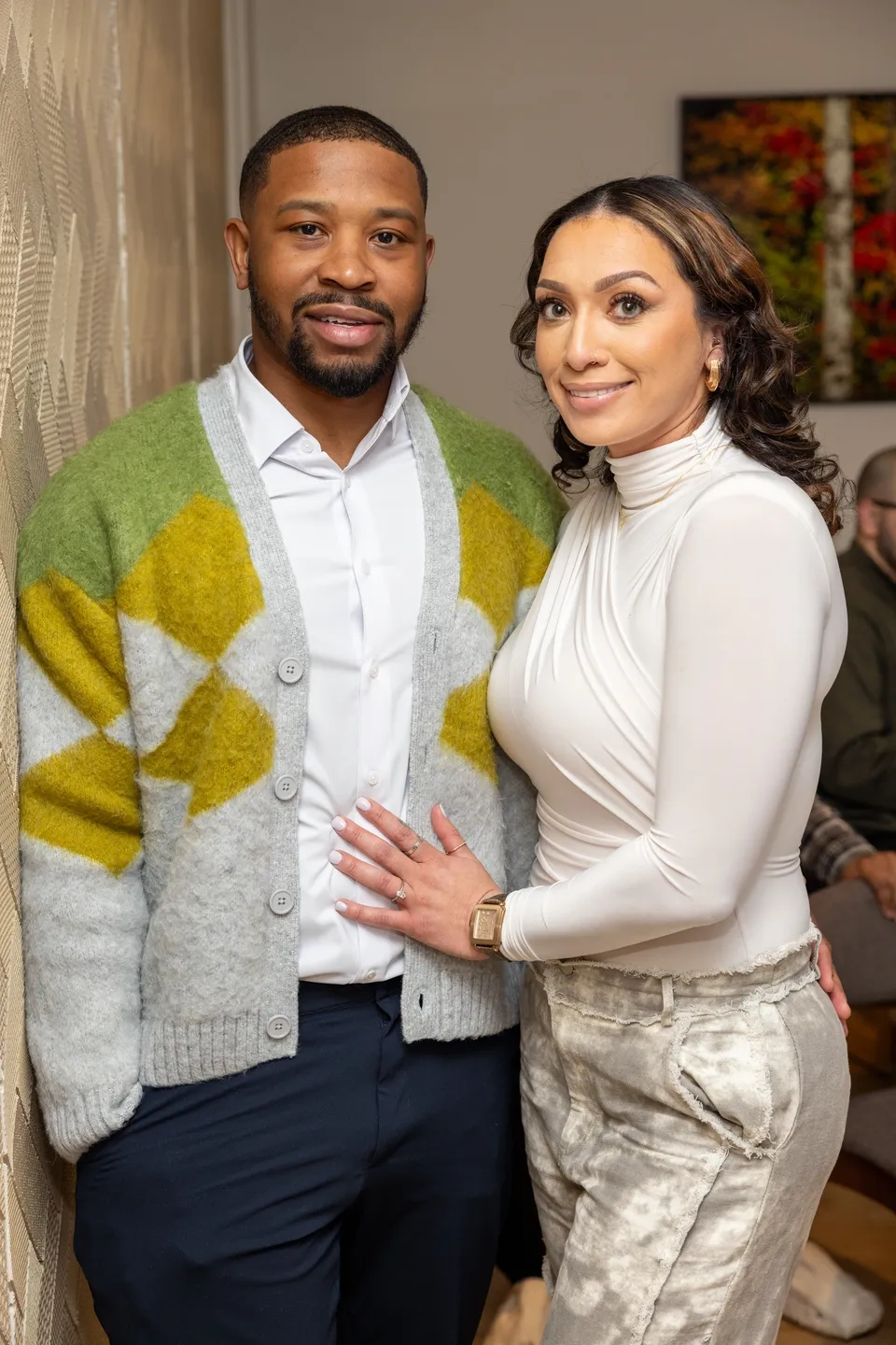 A couple standing close together smiling.