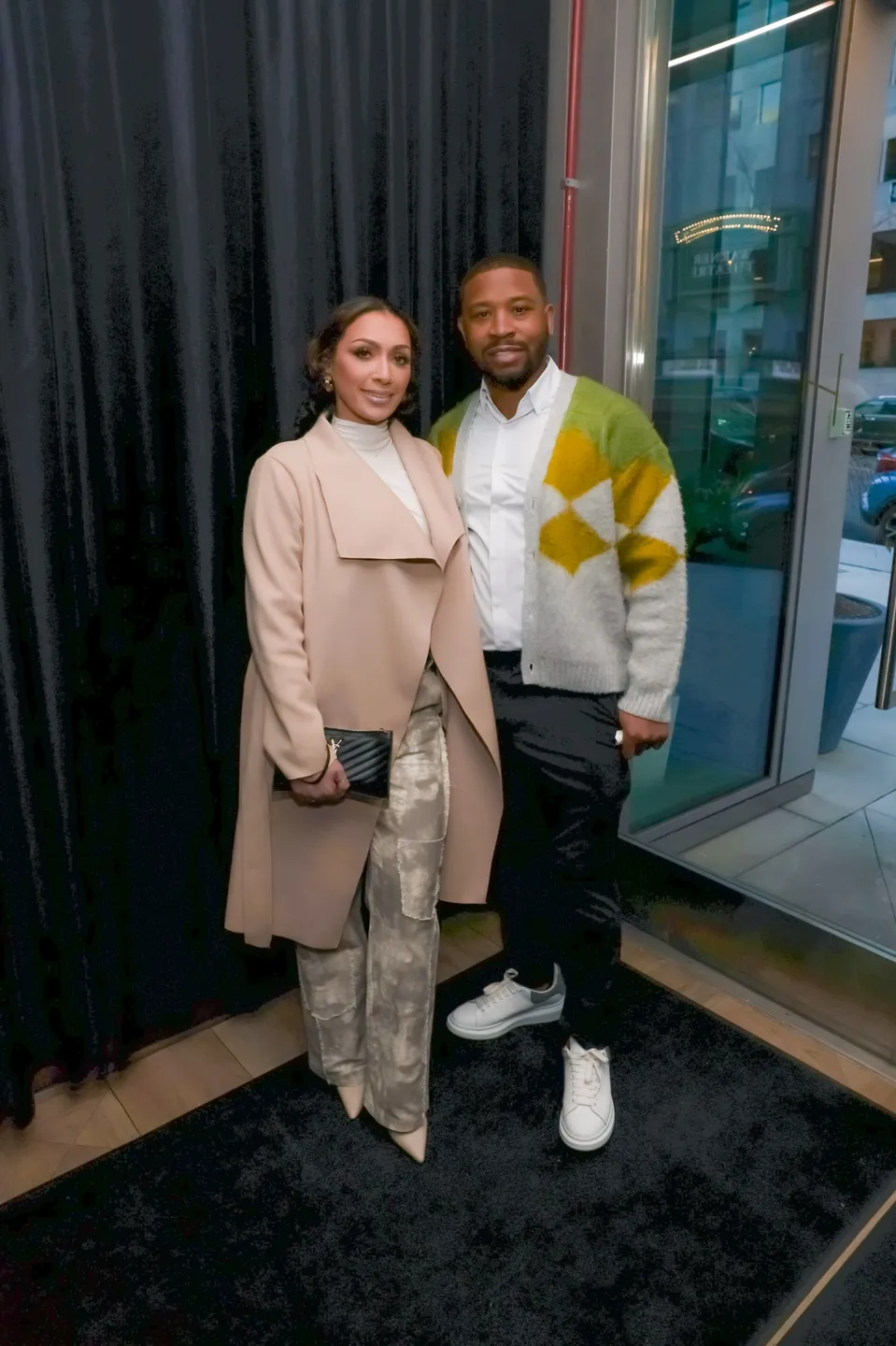 Couple standing in doorway, woman in coat.