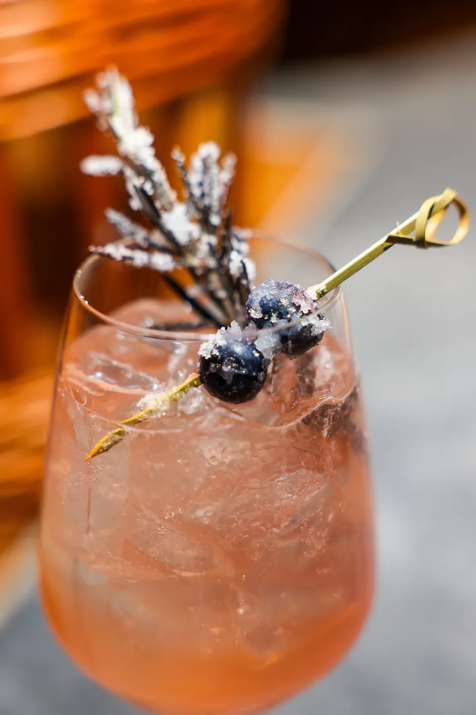 Pink cocktail with blueberries and lavender.